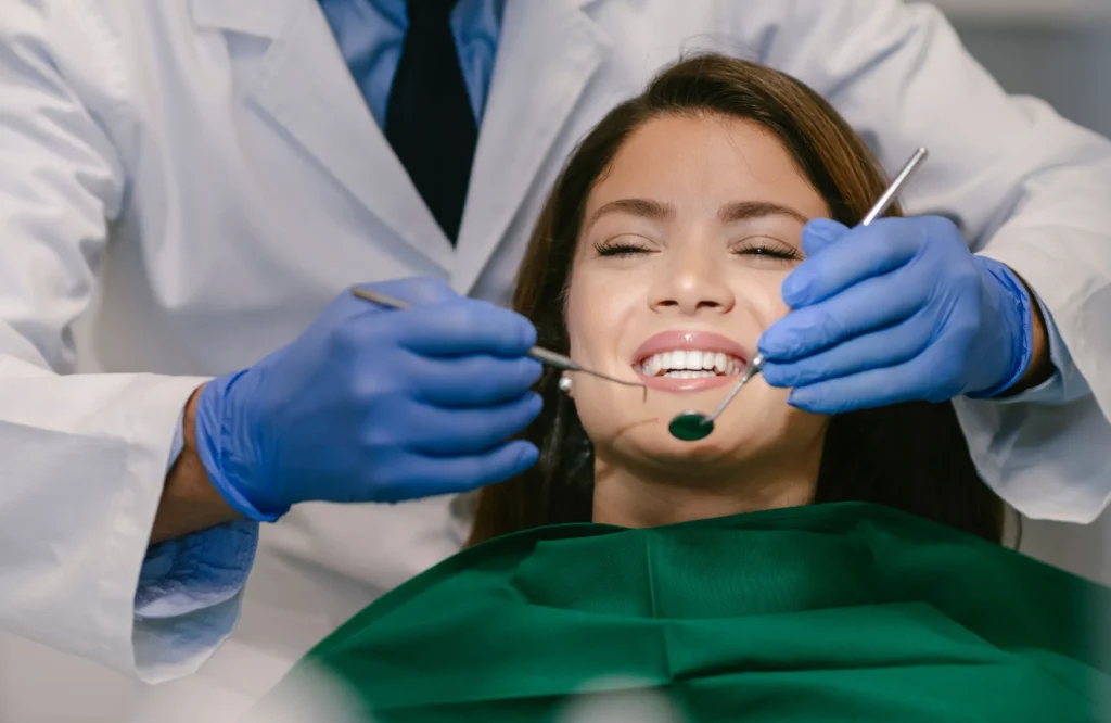 A smiling woman undergoing a dental checkup, representing Pain-Free Dental Treatments in Kokapet: Is It Really Possible?