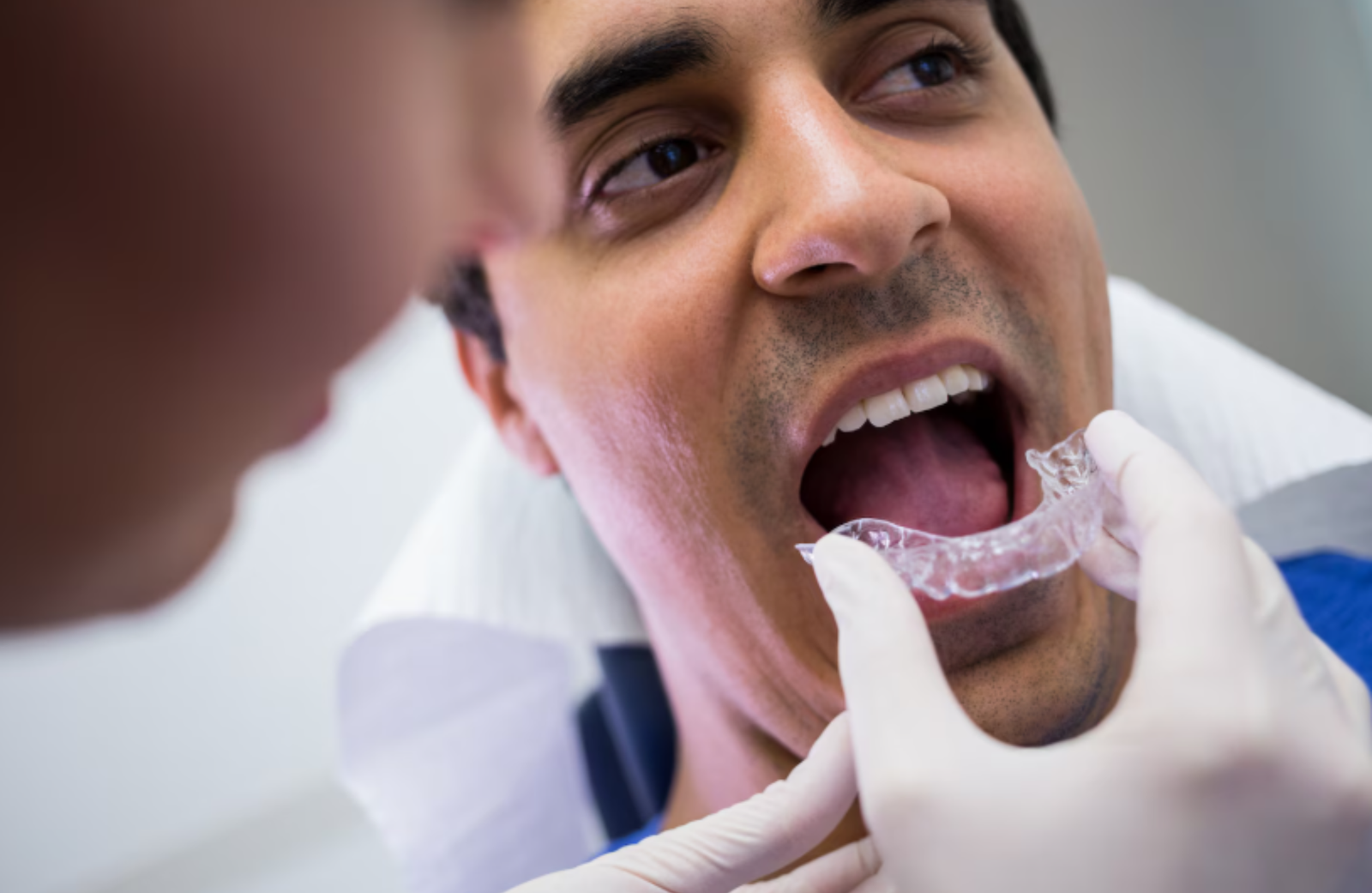 Signs You May Need Invisalign Treatment in Kokapet – Dentist examining patient’s teeth for orthodontic alignment and clear aligner treatment.